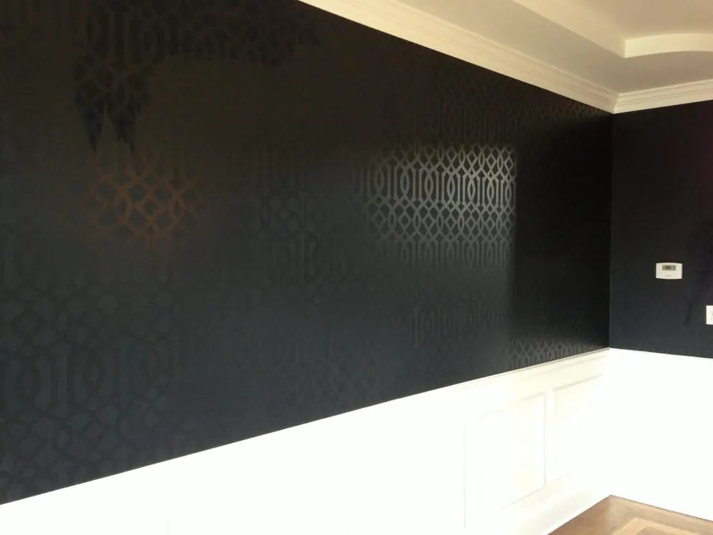 Dining room with painted white wainscoting and dark patterned wallpaper above